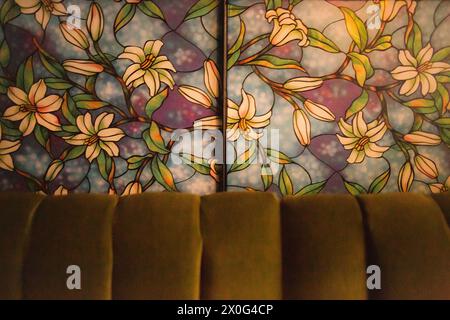 Buntglasfenster im Blumendesign hinter der Couch Stockfoto