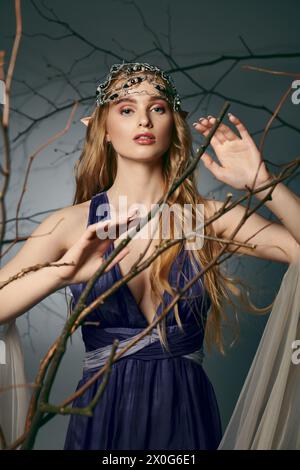 Eine junge Frau in einem blauen Kleid, die eine Krone trägt, verkörpert die Essenz von Fee und Fantasie in einem Studio-Setting. Stockfoto