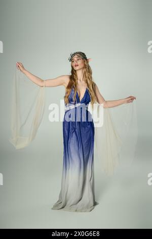 Eine junge Frau in einem blau-weißen Kleid, die das Wesen einer Fee oder Elfenprinzessin in einem traumhaften Studio verkörpert. Stockfoto