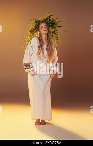 Eine junge Frau mit langen Haaren, gekleidet in einem wunderschönen weißen Kleid, verkörpert die Essenz einer magischen Magie in einem Studio-Setting. Stockfoto