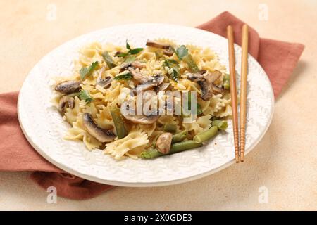 Vegetarische Pasta mit Pilzen, Petersilie, Bohnen und Käse auf orangefarbenen Tischen, Nahaufnahme Stockfoto