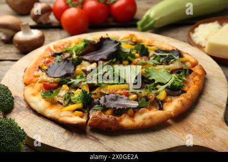 Köstliche vegetarische Pizza und Zutaten auf Holztisch, Nahaufnahme Stockfoto