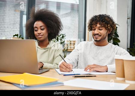 Multikulturelle Studenten studieren gemeinsam mit Laptops in einem modernen Coworking Space. Stockfoto