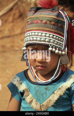 Ein Kind der ethnischen Gruppe der Hmong (MEO) in traditioneller Kleidung in einem Dorf in der Nähe von Chiang Rai. Stockfoto