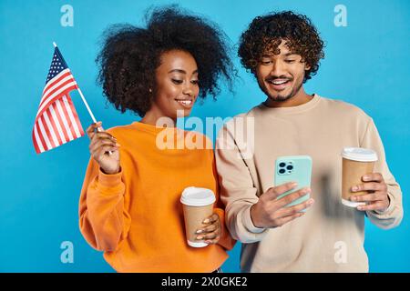Ein interrassisches Paar steht mit einer Tasse Kaffee und einem Handy und genießt einen Moment der Verbindung. Stockfoto