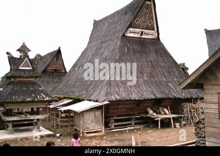 Kinder spielen vor einem typischen Karo-Batak-Haus in Lingga bei Brastiagi. [Automatisierte Übersetzung] Stockfoto