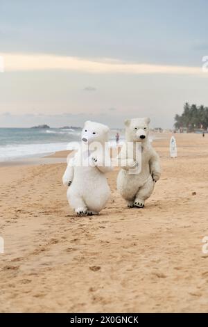 Animateure, die als Eisbären verkleidet sind, unterhalten die Leute am Strand Stockfoto