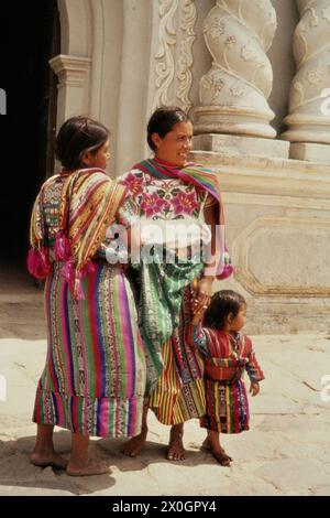 Zwei Quiche Indio Frau mit Kind im traditionellen Kostüm vor einer Kirche in Zunil. Stockfoto