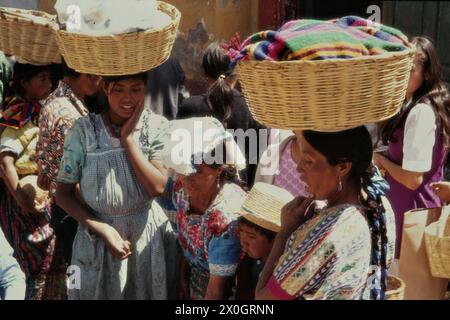 Frauen tragen Körbe mit Kleidung auf ihre Köpfe auf einem Marktplatz in Salcaja (quezaltenango). Stockfoto