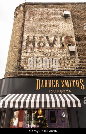 Ein Hovis-Geisterschild auf dem Mauerwerk von BarberSmiths, Camden Passage, Islington, London, N1, England, Großbritannien Stockfoto