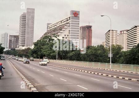 Fahrzeuge auf dem Nicoll Highway in Singapur mit Hochhäusern im Hintergrund. [Automatisierte Übersetzung] Stockfoto