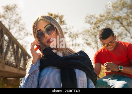 Glückliche Geschäftsfrau, die draußen auf dem Smartphone spricht. Stockfoto