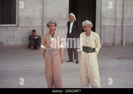 Kurdische Männer im traditionellen Kleid stehen am Bahnhof Mossul. [Automatisierte Übersetzung] Stockfoto
