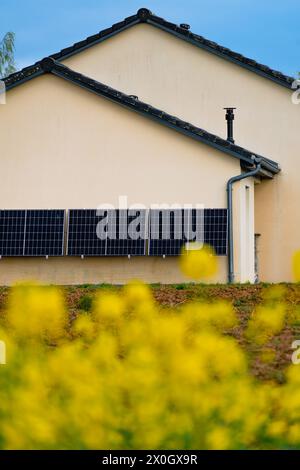 Solarpaneele an einer gut belichteten Wand eines einzelnen Hauses, Einsparungen nach der Energiekrise, Öko-Bürgergeste, grüne Energie Stockfoto