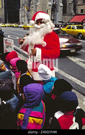 Santa Claus auf der 5th Avenue mit Schulkindern in Midtown [automatisierte Übersetzung] Stockfoto