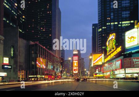 Auf dem Times Square in New York leuchten nachts Neonanzeigen. Die Anzeigen stammen von Camel Lights, Coca-Cola, sbarro und vielen anderen. [Automatisierte Übersetzung] Stockfoto