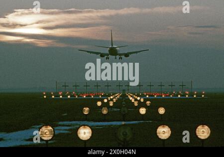 Die Landung eines Flugzeugs in der Nacht auf dem Flughafen München-Riem (Ansicht von Feldkirchen in den Westen). Vor der Runway Lights. Stockfoto