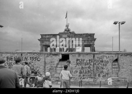 Wenige Tage vor der Maueröffnung patrouillieren zwei Grenzsoldaten vor dem Brandenburger Tor in Berlin über die Mauerkrone. [Automatisierte Übersetzung] Stockfoto