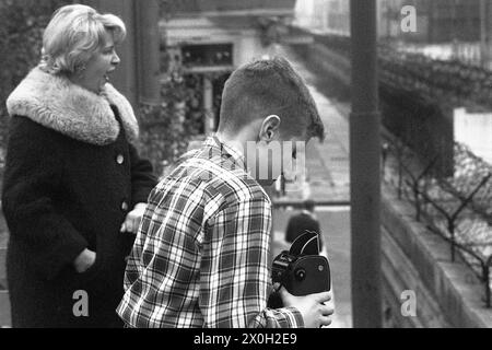 Eine Mutter und ihr Kind sind auf der Suche nach Osten über die Berliner Mauer in Kreuzberg. Der Junge macht ein Foto von der Grenze streifen. Stockfoto