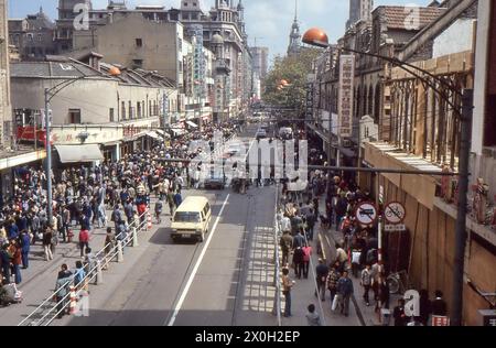 Fußgänger und Autos auf der Nanjing Road in Shanghai in China. Stockfoto