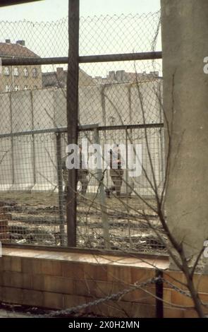 DDR-Grenzschutzbeamte patrouillieren in der Bernauer Straße in Berlin. Stockfoto