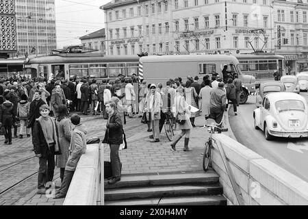 Während eine entgleiste Straßenbahn im Hintergrund auf die Gleise zurückgezogen wird, schlängelt sich der Verkehr davor ohne die Anwesenheit von Polizisten vorbei. [Automatisierte Übersetzung] Stockfoto