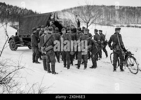 Ein Fernmeldezug der Wehrmacht macht macht macht macht Halt in einer verschneiten Landschaft in Frankreich. Zu der Gruppe gehört auch ein Radsoldat. Das Bild wurde in Frankreich von einem Mitglied des 154. Infanterieregiments/58. Infanteriedivision aufgenommen. [Automatisierte Übersetzung] Stockfoto