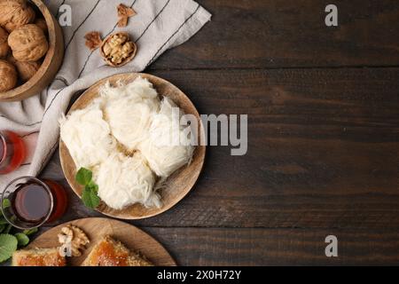 Östliche Süßigkeiten. Leckerer iranischer Paschmak und Tee auf Holztisch, flach gelegen. Leerzeichen für Text Stockfoto
