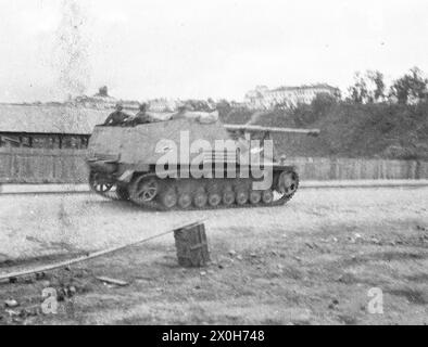 Ein deutscher Panzerzerstörer Nashorn fährt durch eine Stadt an der Ostfront. Das Foto wurde im hinteren Teil der Ostfront aufgenommen, vermutlich im Zusammenhang mit Partisanenkämpfen. Das Bild wurde von einem Mitglied des Radfahrgrenadierregiments 2 im Nordteil der Ostfront aufgenommen. [Automatisierte Übersetzung] Stockfoto