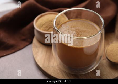 Lösliche Faser mit Wasser in Glas und Pulver auf braunem Tisch, Nahaufnahme Stockfoto