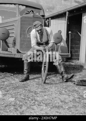 Ein Soldat sitzt auf dem Stoßfänger eines Lastwagens und repariert seinen Fahrradreifen. Das Bild wurde von einem Mitglied des 154. Infanterieregiments/58. Infanteriedivision in Frankreich aufgenommen. [Automatisierte Übersetzung] Stockfoto