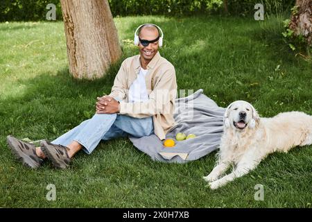 Ein Mann mit Myasthenia gravis-Syndrom sitzt auf einer Decke neben seinem treuen Labrador-Hund, verloren in Gedanken. Stockfoto