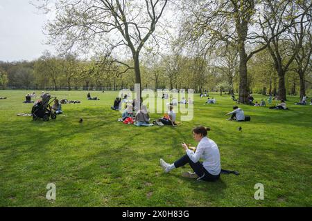 London, Großbritannien. 12. April 2024. Die Menschen entspannen sich in der warmen Sonne im Green Park London, da die Temperaturen am Wochenende voraussichtlich steigen werden. Quelle: amer Gazzal/Alamy Live News Stockfoto