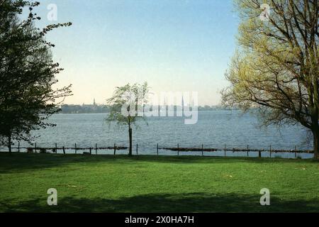 Blick vom Alsterufer über die Alster, den Fernsehturm und die dortige Hamburger Skyline, ganz links das Brückenensemble von der inneren Alster zur Außenalster Langobarden-, Eisenbahn- und Kennedbrücke Stockfoto