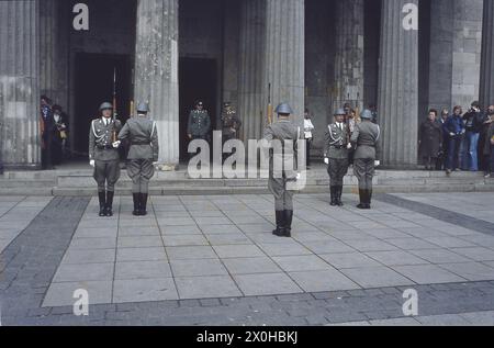 Der Wachwechsel an der neuen Wache in Berlin zieht viele internationale Besucher an. Die Wachen folgen einer strengen Zeremonie, tragen Uniformen mit Helmen und halten ihre Gewehre. Undatiertes Foto, ca. 1980. [Automatisierte Übersetzung] Stockfoto