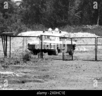 "Das ist das Folgebild zum vorherigen, vielleicht Timeline.Bilder können die beiden Bilder verbinden: Als Eisenbahnfreund in West-Berlin haben Sie sich kaum auf dem Damm der S-Bahn-Strecke Köllnische Heide – Baumschulenweg eingerichtet, die nach dem Mauerbau stillgelegt wurde, um Züge der Görlitzer Bahn in Richtung Grünau zu fotografieren, während auf der anderen Seite bereits ein Volkspolizeiwagen steht. Nichts Schlechtes an sich. Interessant wurde es erst, als ich in der hier gezeigten extremen Vergrößerung etwas rundliches in der hinteren Seitenscheibe entdeckte (daher die Unschärfe). Auch A Stockfoto