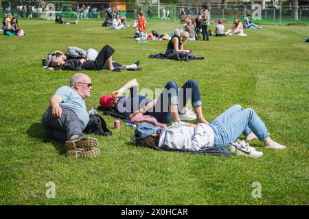 London, Großbritannien. 12. April 2024. Die Menschen entspannen sich in der warmen Sonne im Green Park London, da die Temperaturen am Wochenende voraussichtlich steigen werden. Quelle: amer Gazzal/Alamy Live News Stockfoto