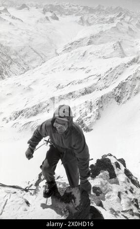 Ein Skitourenfahrer mit einem Skistock in der Hand steigt auf den Gipfel der Wildspitze [automatisierte Übersetzung] Stockfoto