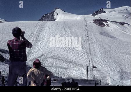 Im Sommerskigebiet beobachten die Trockener Steg Touristen das Skifahren. [Automatisierte Übersetzung] Stockfoto