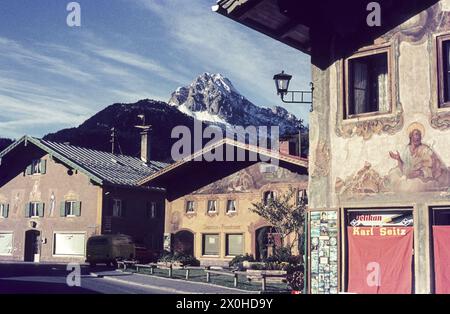 Das Hornsteinerhaus und die faÃ-Fassade des Hauses in der Matthias-Klotz Straße 11 im Herbst. Lüftlmalerei auf beiden Häusern. Die Schaufenster sind abgedeckt. Die schneebedeckten Wettersteinberge im Hintergrund. [Automatisierte Übersetzung] Stockfoto