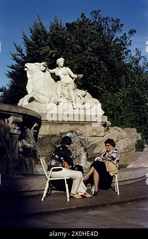 Zwei Frauen ruhen sich vor dem Brunnen aus. [Automatisierte Übersetzung] Stockfoto