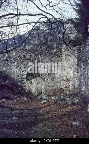 Überreste der Burgmauern im Frühjahr, dahinter ein Berg mit Schneereste. [Automatisierte Übersetzung] Stockfoto