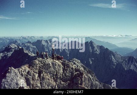 Auf dem Ostgipfel stehen Wanderer um das Gipfelkreuz. Panorama an einem sehr klaren Tag. [Automatisierte Übersetzung] Stockfoto