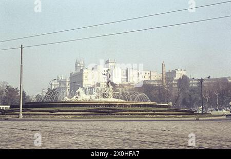 Der Neptunbrunnen in der Mitte des Platzes. Der Platz ist fast ohne Autos. Hinten die Häuser entlang des Paseo del Prado [automatisierte Übersetzung] Stockfoto