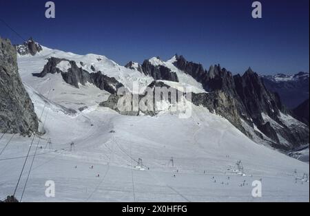 Unter den Hängeseilen der Gondelbahn Aiguille du Midi - Helbronner auf dem Gletscher du GÃ mit Skifahrern auf der Skipiste. [Automatisierte Übersetzung] Stockfoto