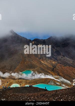 Touristen genießen den smaragdgrünen See entlang des Tongariro Alpine Crossing Trail, Tongariro National Park, Nordinsel, Neuseeland Stockfoto