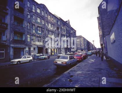 Blick auf eine Straße im ehemaligen Ost-Berlin kurz nach der Wiedervereinigung. Die Häuser links und rechts von der Straße sind sehr heruntergekommen und verfallen. [Automatisierte Übersetzung] Stockfoto