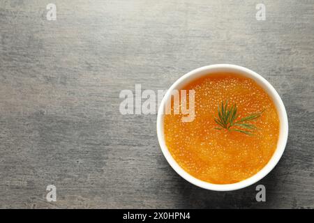 Frischer Hechtkaviar und Dill in Schüssel auf grauem Tisch, Draufsicht. Leerzeichen für Text Stockfoto