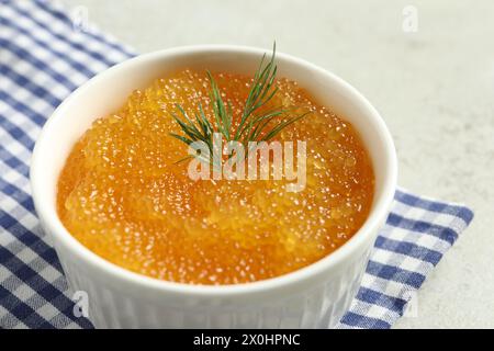 Frischer Hechtkaviar und Dill in Schüssel auf hellgrauem Tisch, Nahaufnahme Stockfoto