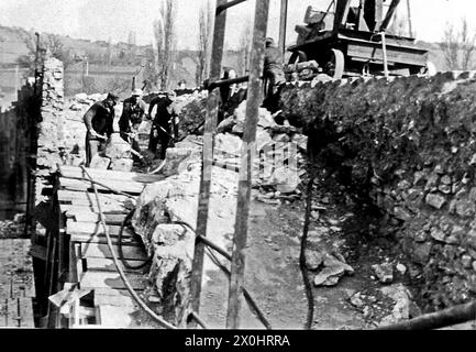 Am 1. April 1945 sprengten deutsche Einheiten Arch 6 in der Mitte der Brücke. In den folgenden Jahren überspannte eine provisorische Holzkonstruktion die Lücke im Gebäude. Der Eröffnung der Neuen Hauptbrücke 1954 folgte der Wiederaufbau der Alten Hauptbrücke, der 1957 abgeschlossen wurde. Durch den Ausbau des Mains zu einer wichtigen Schifffahrtsroute wurden die drei Mittelbögen fünf bis sieben durch einen rund 58 Meter langen Spannbetonbalken ersetzt, der den Main überspannte, der durch das Goßmannsdorfer Stauwerk gestaut wurde. [Automatisierte Übersetzung] Stockfoto